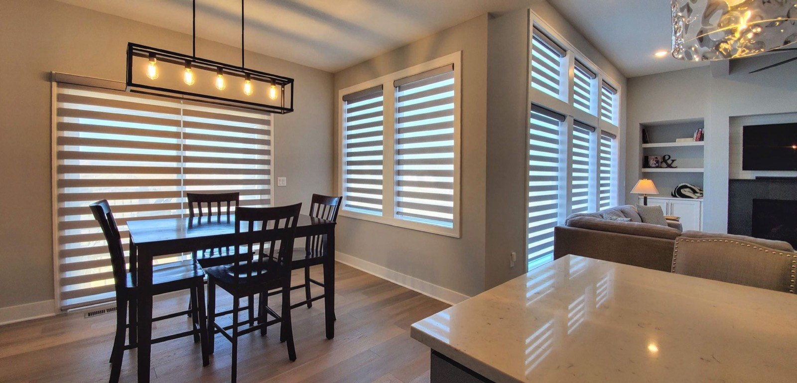 Banded shades across kitchen and dining area windows
